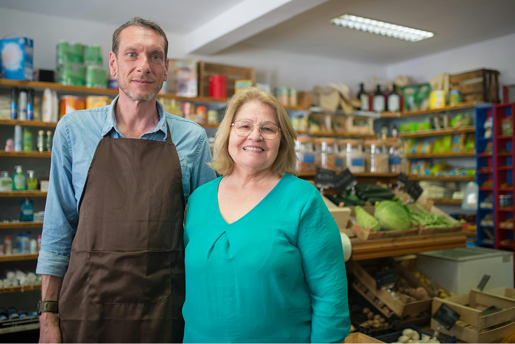 Market owners smiling in their shop